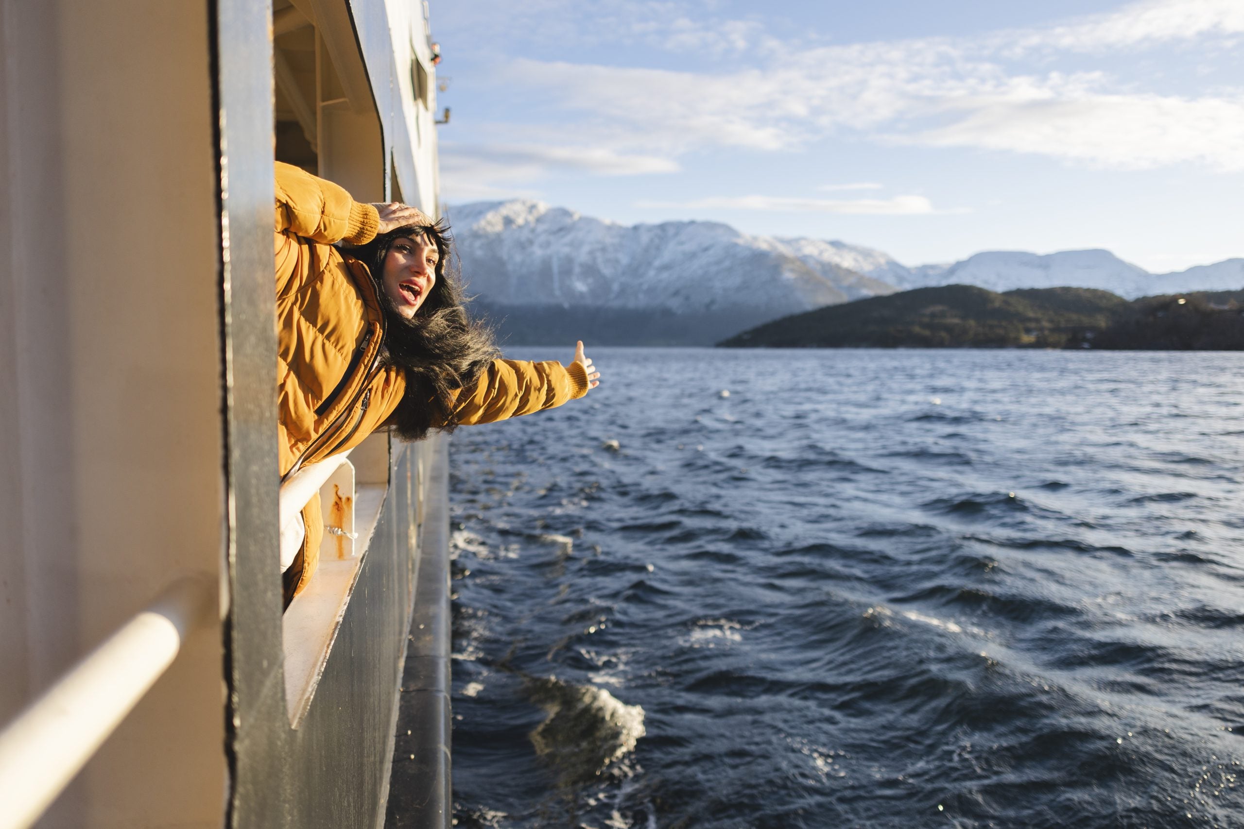 excited-woman-leans-out-of-a-ferry-enjoying-the-f-2026-01-09-06-23-11-utc